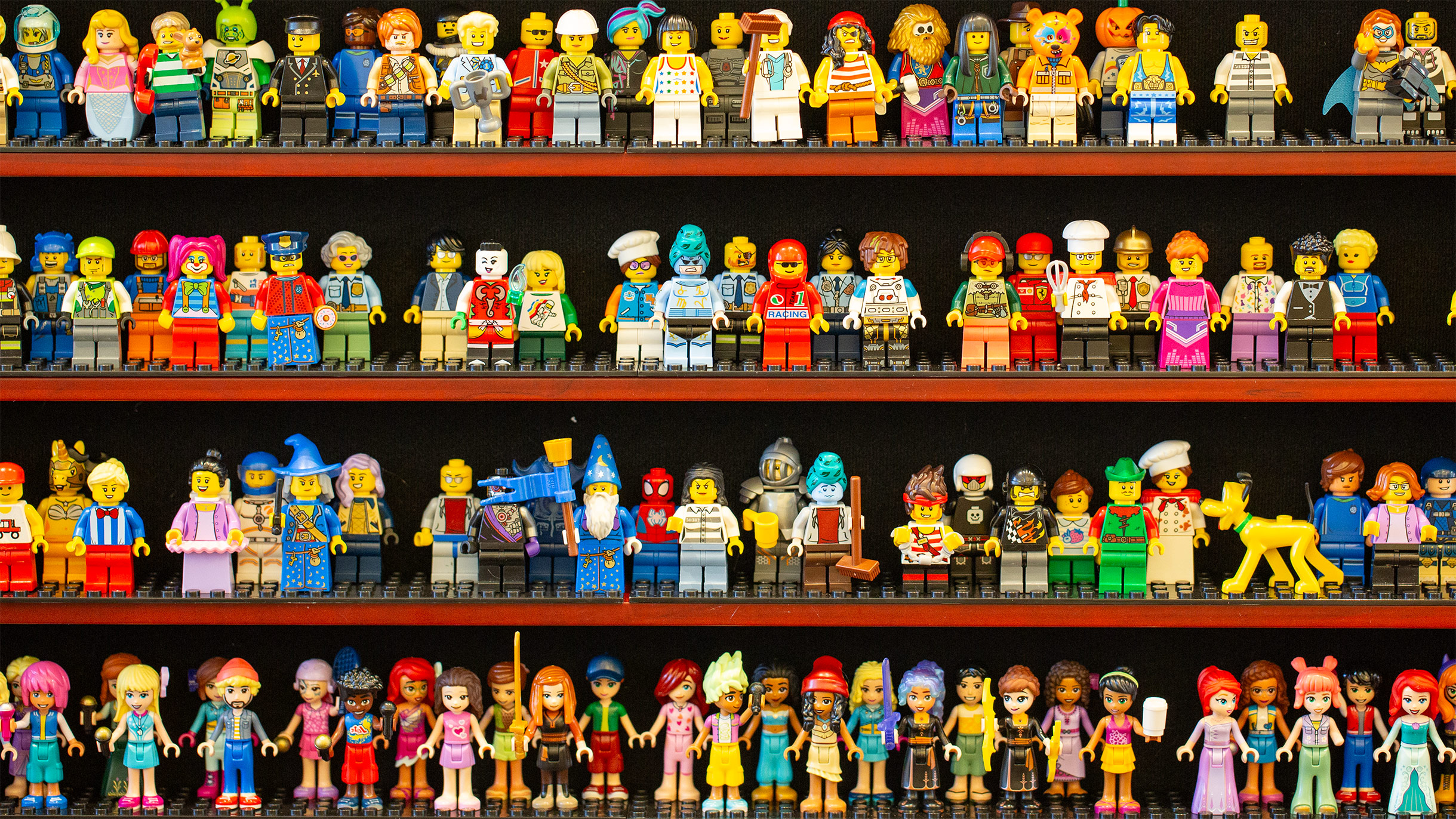 Large LEGO minifigure collection displayed on shelves, representing the breadth of upcoming themes